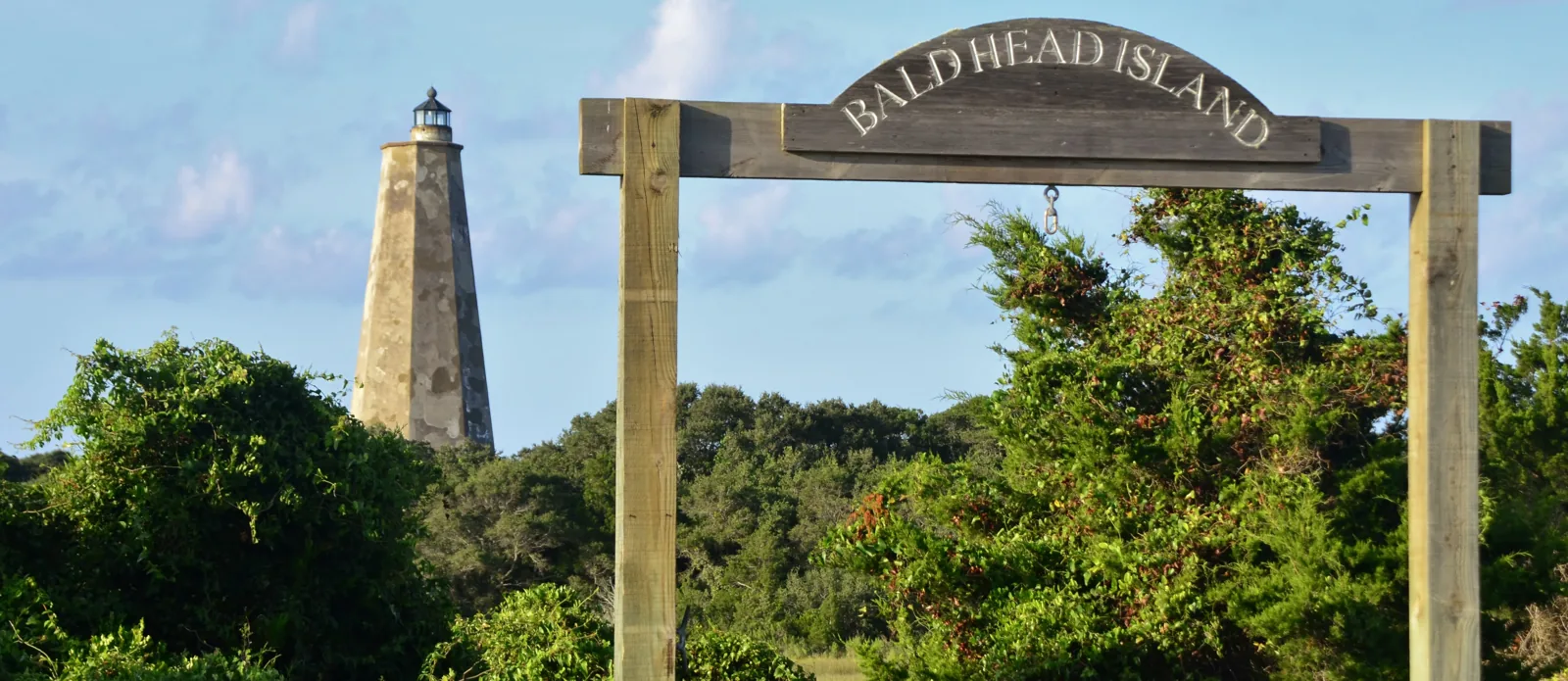 Old Baldy Lighthouse behind the island gateway and coastal vegetation