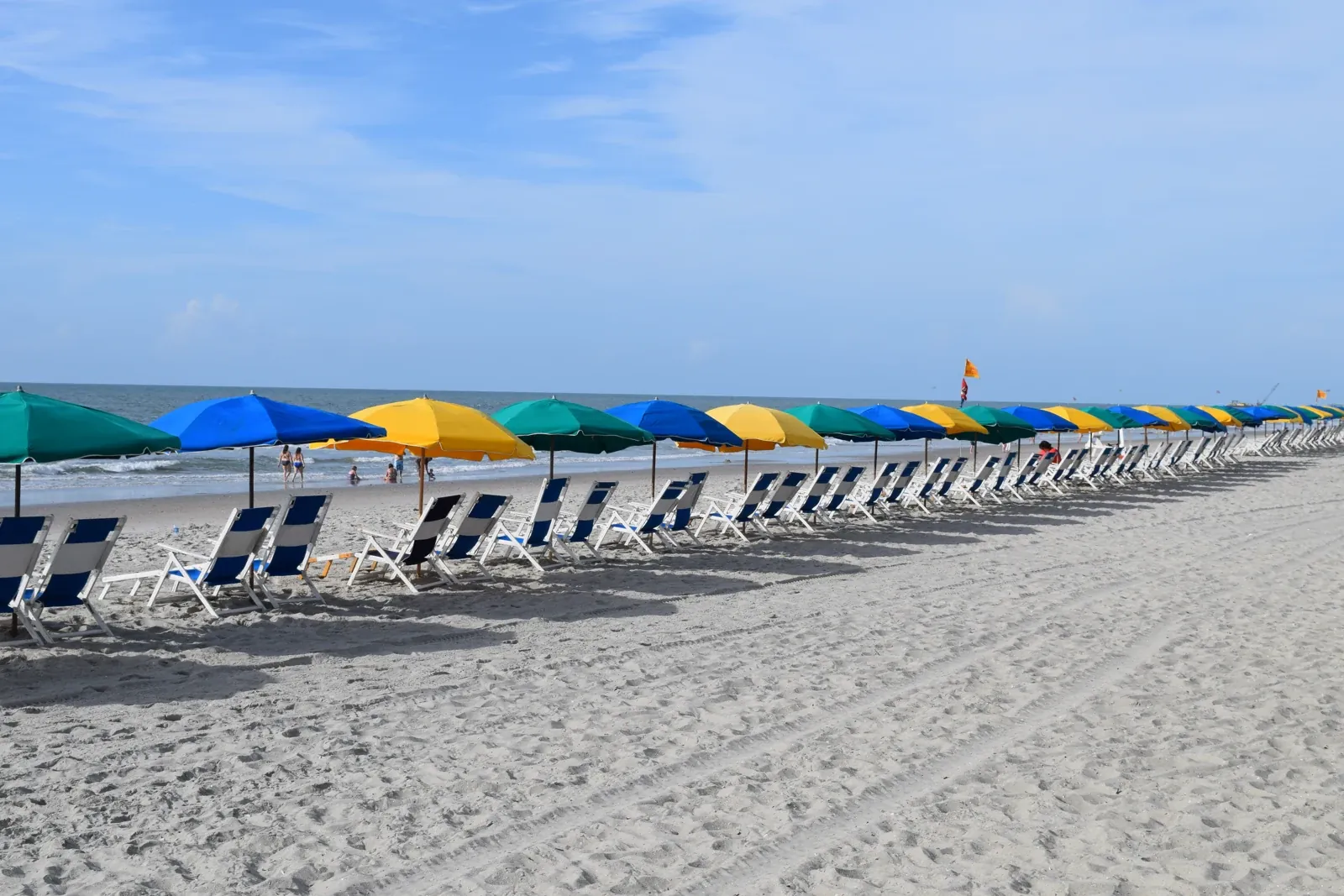 Colorful beach umbrellas and chairs beside the ocean at North Myrtle Beach